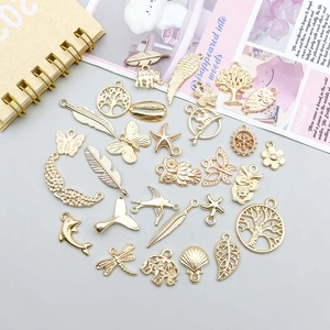 Detailed close-up of mixed gold alloy charms like butterfly and owl for DIY jewelry making