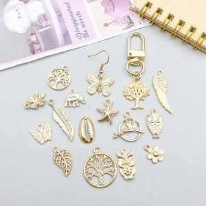Detailed flat lay of assorted golden alloy charms including butterflies and animals for DIY