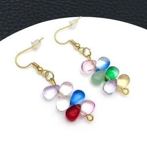 Detailed view of assorted colorful glass teardrop pendants with golden metal ear hooks