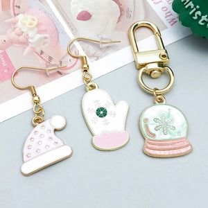 Close-up of pink Christmas hat and white glove enamel charms with gold-plated alloy finish