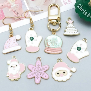 Detail of pink and white enamel Christmas charms including snowflakes and holiday trees