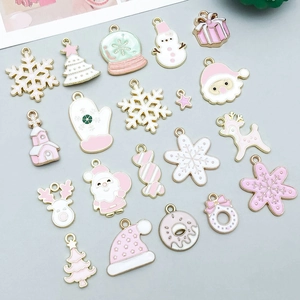 Detailed flat lay of 20 festive enamel Christmas pendants in pink and gold tones