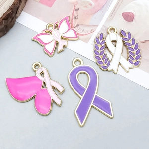 Dettaglio di ciondoli a cuore e nastro in smalto rosa e viola con bordi in metallo dorato