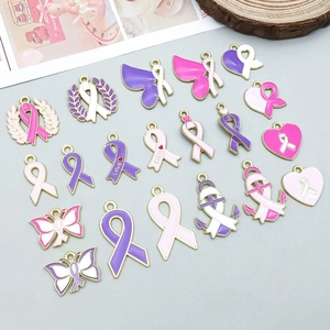 Dettaglio di ciondoli in smalto rosa e viola a forma di cuore e fiocco per gioielli