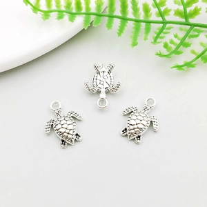 Detailed top view of three antique silver turtle charms for DIY jewelry making