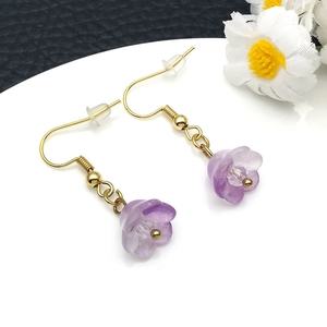 Macro shot of lily of the valley earrings with purple frosted petals and golden fish hooks