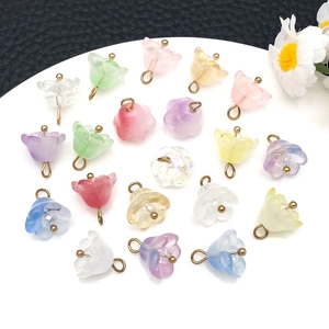 Macro view of colorful lily of the valley glass charms with golden metal loops