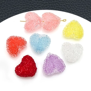 Close-up of frosted acrylic heart charms with embedded rhinestones for DIY jewelry making