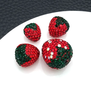 Macro shot of sparkling red rhinestone strawberry charms for DIY jewelry making