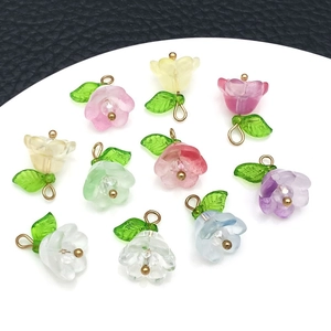 Flat lay of colorful lily of the valley flower pendants with golden rings for DIY jewelry