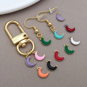 Macro detail of colorful enamel moon pendants with gold trim for DIY jewelry making