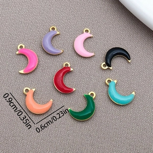 Macro detail of eight colorful enamel crescent moon pendants in gold stainless steel