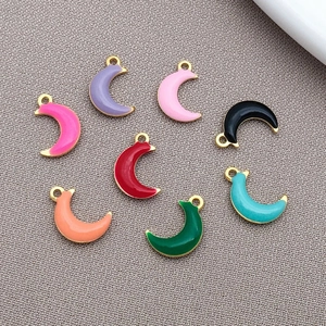 Detailed view of eight colorful enamel crescent moon charms for DIY jewelry making