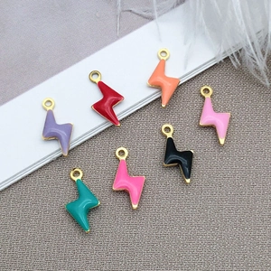 Macro detail of lightning bolt charms with colorful enamel finish and gold plated borders