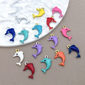 Close-up of colorful enamel dolphin charms for DIY necklaces with gold and silver edges