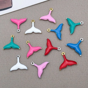 Detailed view of colorful double-sided enamel mermaid tail pendants for DIY jewelry