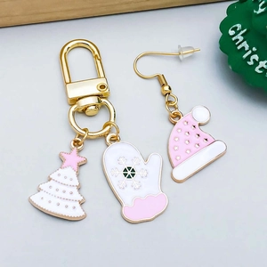 Detailed view of pink and white enamel Christmas tree and snowflake glove charms on alloy