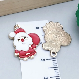 Macro-opname van de kerstman emaille hangers met afmetingen op een liniaal