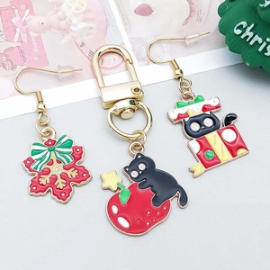 Detailed view of Christmas themed charms featuring black cat and snowflake enamel designs