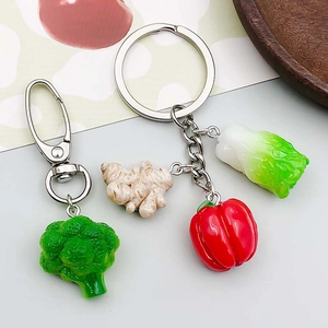 Détail de breloques en résine en forme de légumes comme le brocoli, gingembre et poivron
