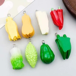Vue à plat de breloques légumes en résine colorée comme citrouille et poivron pour bijoux