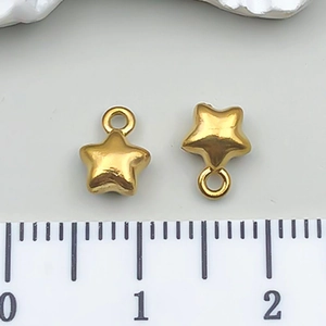 Vista macro de colgantes de estrella dorada de 8 mm con anillos para joyería artesanal