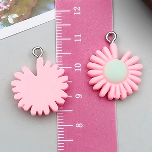 Detail of pink resin flower pendants showing front and back with ruler measurement
