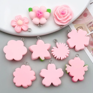 Detailed view of pink resin flower pendants including roses and cherry blossoms for DIY jewelry