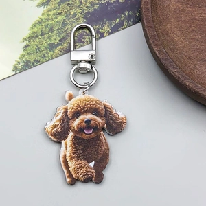 Detail view of acrylic puppy pendant with double-sided poodle print and silver metal clasp