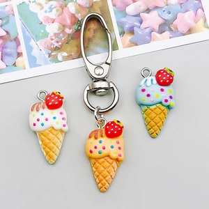 Macro detail of colorful resin ice cream cone pendants with strawberry and lobster clasp