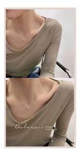 Gros plan du collier avec pendentif cœur argenté minimaliste sur la clavicule