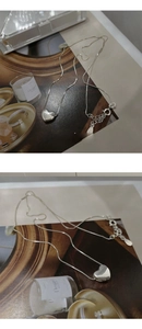 Vue détaillée du pendentif cœur argenté sur une fine chaîne maille miroir avec fermoir