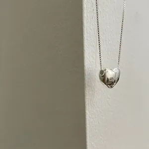 Gros plan d'un collier pendentif coeur en argent avec une chaîne maille vénitienne