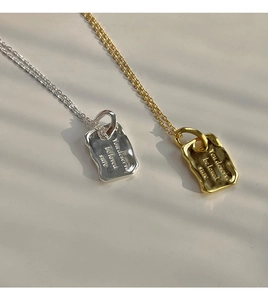 Makro-Detail von Gold- und Silber-Halsketten mit eingraviertem Motivations-Text