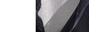 Detailansicht der dunklen Stricktextur und Knöpfe mit weißen Gewebeschichten
