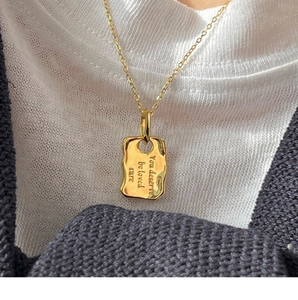 Detailansicht goldener Umschlag-Anhänger mit Gravur auf einer Gliederkette