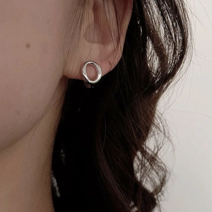 Boucles d'oreilles créoles ovales géométriques en argent portées par un mannequin chic
