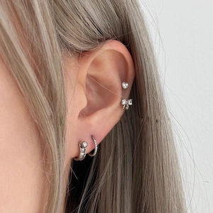Set di orecchini a lobo con fiocco e cuore in argento e zirconi su modella