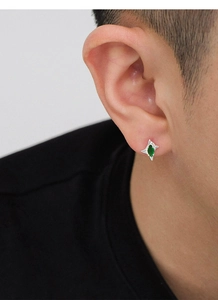 Primer plano de pendiente de estrella plateada con piedra marquesa verde en un modelo