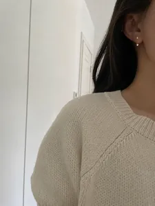 Primer plano de pendientes minimalistas de doble cara con circonita y perla en modelo