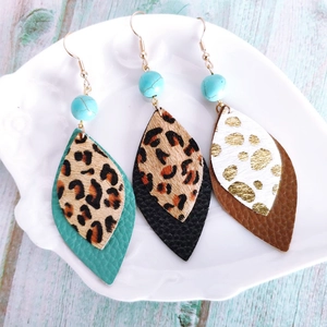 Detail view of Bohemian leather leaf earrings with leopard print and turquoise beads