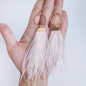 Bohemian gold circular earrings with soft pink feather tassels and textured metal finish