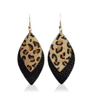 Detail of bohemian leaf earrings with leopard print fur and black textured leather layers