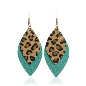 Detail of bohemian leaf earrings featuring leopard print fur and turquoise leather texture