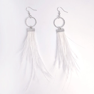 Detailed view of white feather tassel earrings with polished round metal rings and hooks