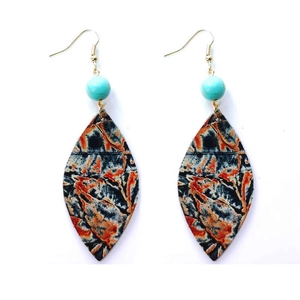 Détail de boucles d'oreilles en cuir vintage avec perle turquoise et motif artistique