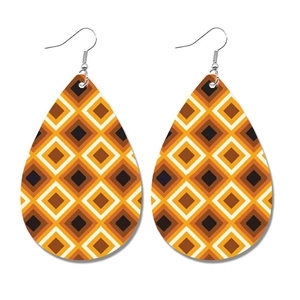 Detail van druppelvormige leren oorbellen met retro oranje en bruin geometrisch patroon