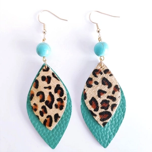 Macro view of bohemian tiered leaf earrings with leopard pony hair and turquoise leather
