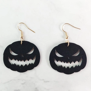 Detalle de pendientes de calabaza negra de Halloween con ganchos dorados finos