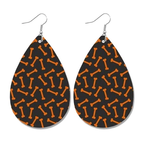 Detail van druppelvormige leren oorbellen met oranje botpatronen voor Halloween